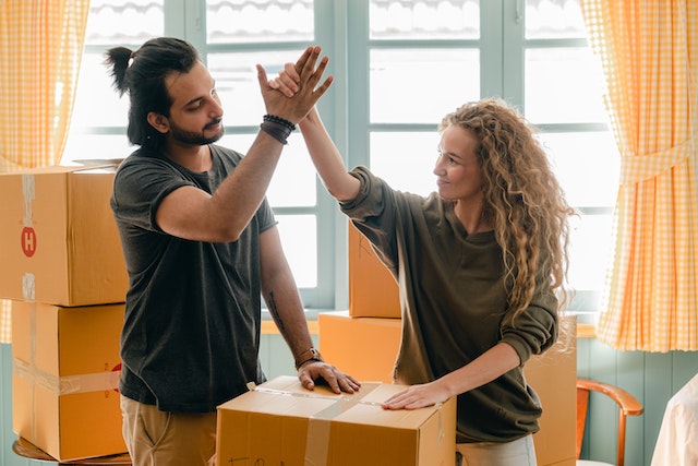 Happy couple high-fiving after packing for their move.